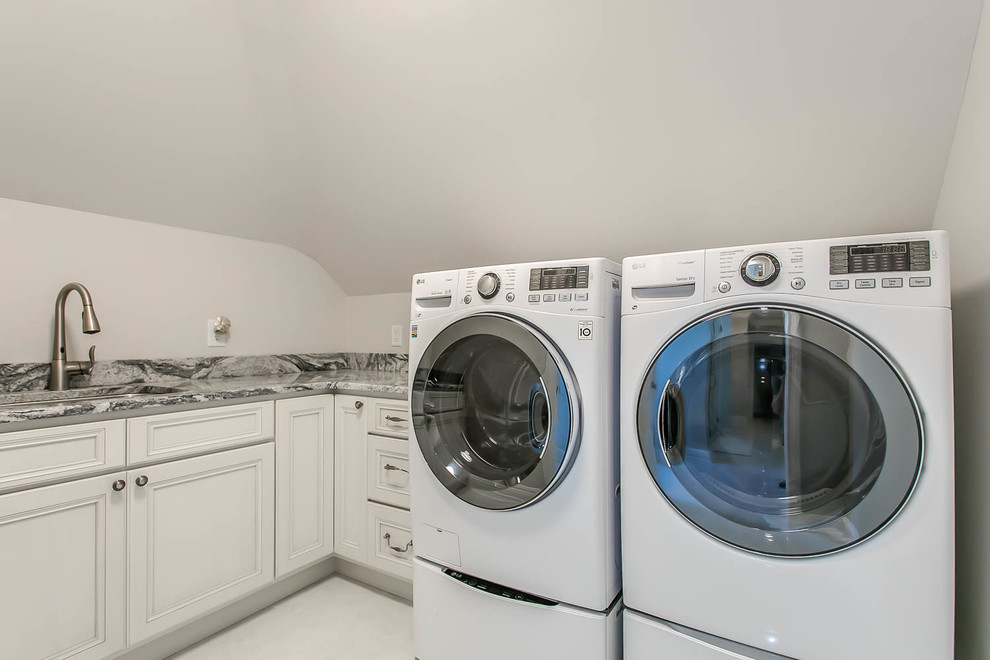 Immagine di una lavanderia chic con lavello sottopiano, ante lisce, ante bianche, top in quarzo composito, pavimento in marmo, pavimento marrone e top bianco