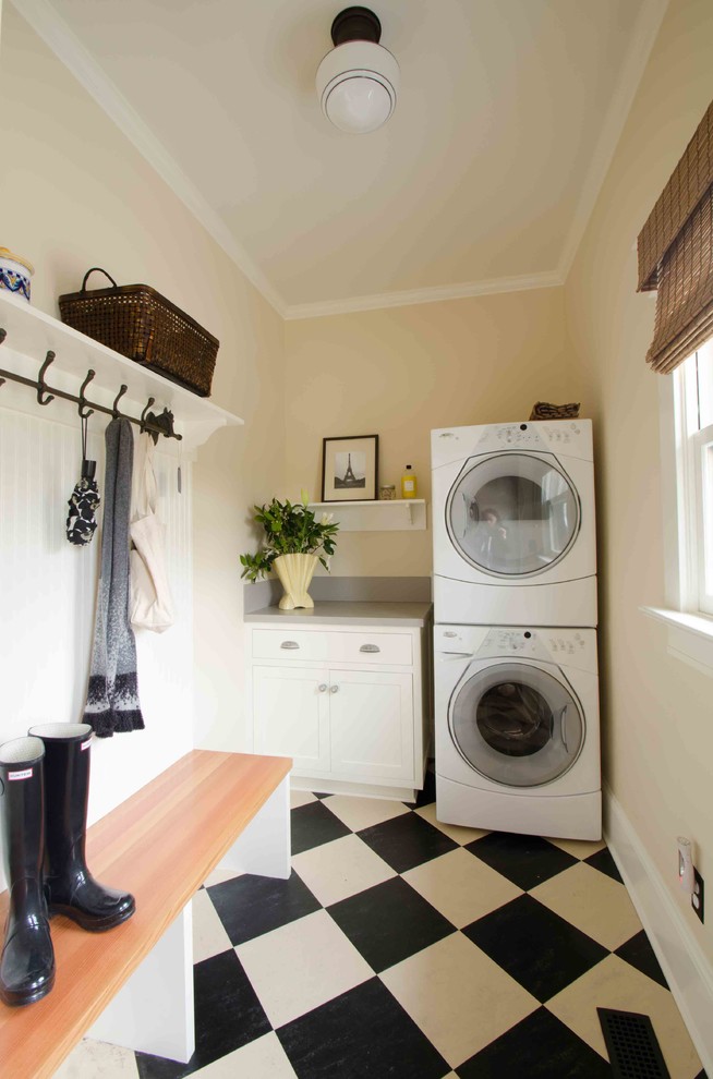 Immagine di una lavanderia multiuso classica di medie dimensioni con ante in stile shaker, ante bianche, top in quarzo composito, pareti beige e lavatrice e asciugatrice a colonna