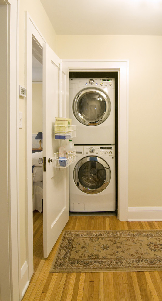 Ispirazione per un ripostiglio-lavanderia classico con lavatrice e asciugatrice a colonna