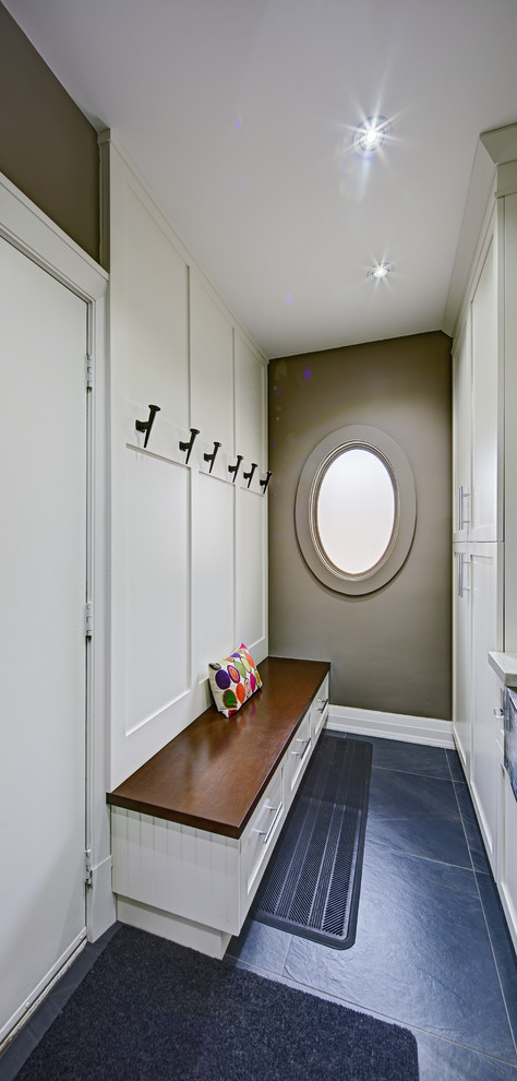 Cette image montre une petite buanderie parallèle dédiée avec un évier de ferme, un placard à porte shaker, des portes de placard blanches, un plan de travail en quartz modifié, un mur gris et un sol bleu.