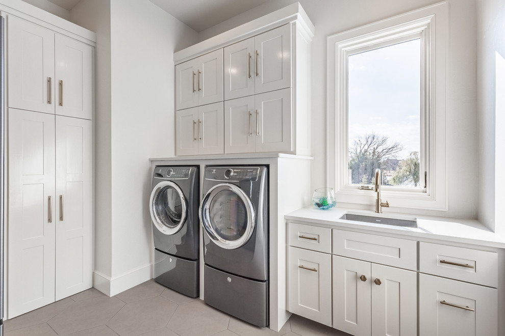 Diseño de lavadero clásico renovado con fregadero bajoencimera, armarios estilo shaker, puertas de armario blancas, paredes blancas y lavadora y secadora juntas