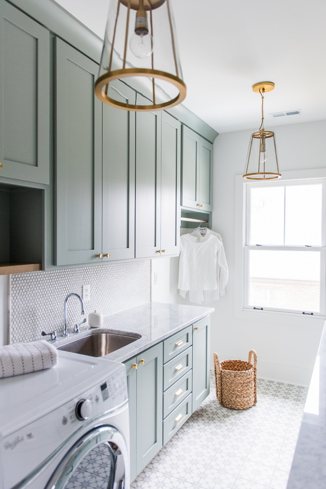 Bild på en mellanstor amerikansk parallell tvättstuga enbart för tvätt, med skåp i shakerstil, gröna skåp, marmorbänkskiva, vita väggar, betonggolv, en tvättmaskin och torktumlare bredvid varandra och en undermonterad diskho
