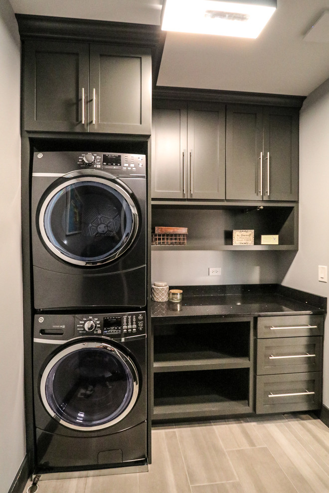 Mittelgroße Klassische Waschküche mit Quarzwerkstein-Arbeitsplatte, grauer Wandfarbe, Porzellan-Bodenfliesen und Waschmaschine und Trockner gestapelt in Chicago