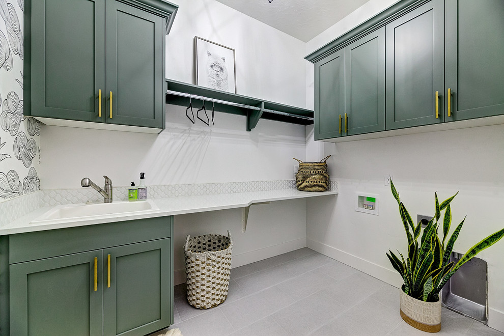 Photo of a large farmhouse l-shaped separated utility room in Boise with a built-in sink, shaker cabinets, green cabinets, engineered stone countertops, white walls, porcelain flooring, a side by side washer and dryer, grey floors and white worktops.