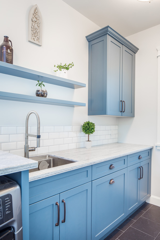 Design ideas for a small rural galley utility room in Vancouver with a submerged sink, shaker cabinets, blue cabinets, composite countertops, grey walls, porcelain flooring, a side by side washer and dryer, grey floors and grey worktops.