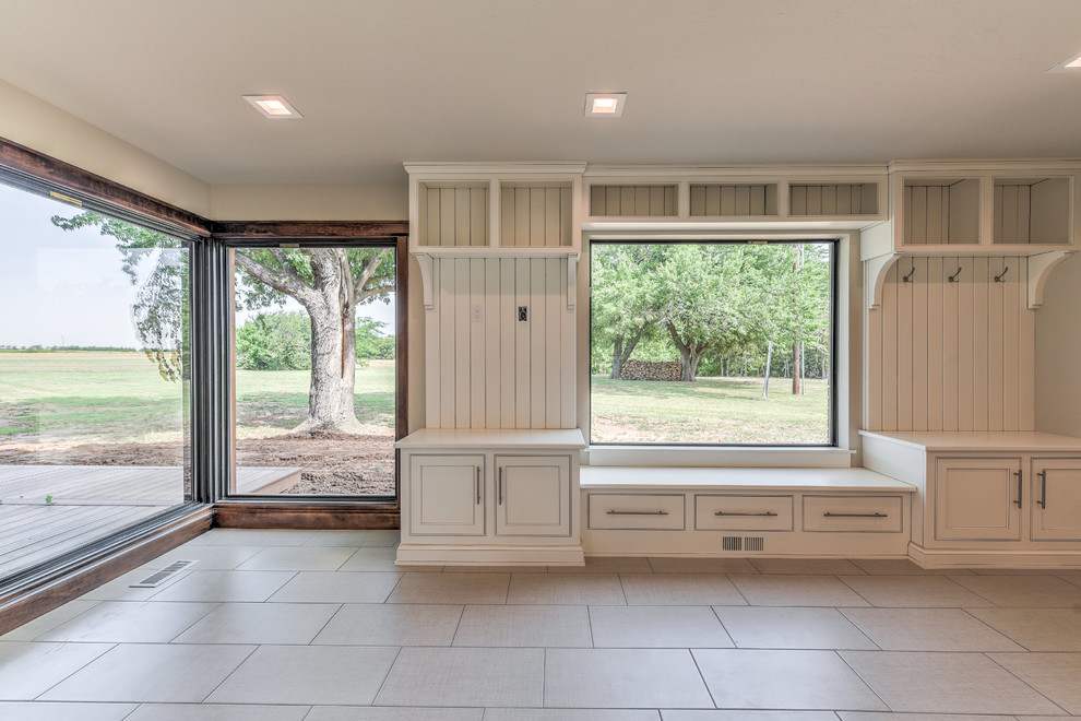 Inspiration for a large farmhouse u-shaped vinyl floor and gray floor utility room remodel in Oklahoma City with shaker cabinets, white cabinets, wood countertops, gray walls and a side-by-side washer/dryer
