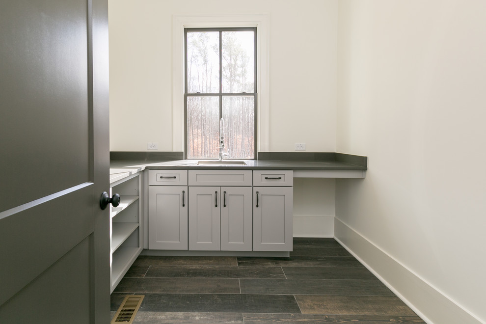 Immagine di una grande sala lavanderia country con ante in stile shaker, ante grigie, top in granito e pavimento con piastrelle in ceramica