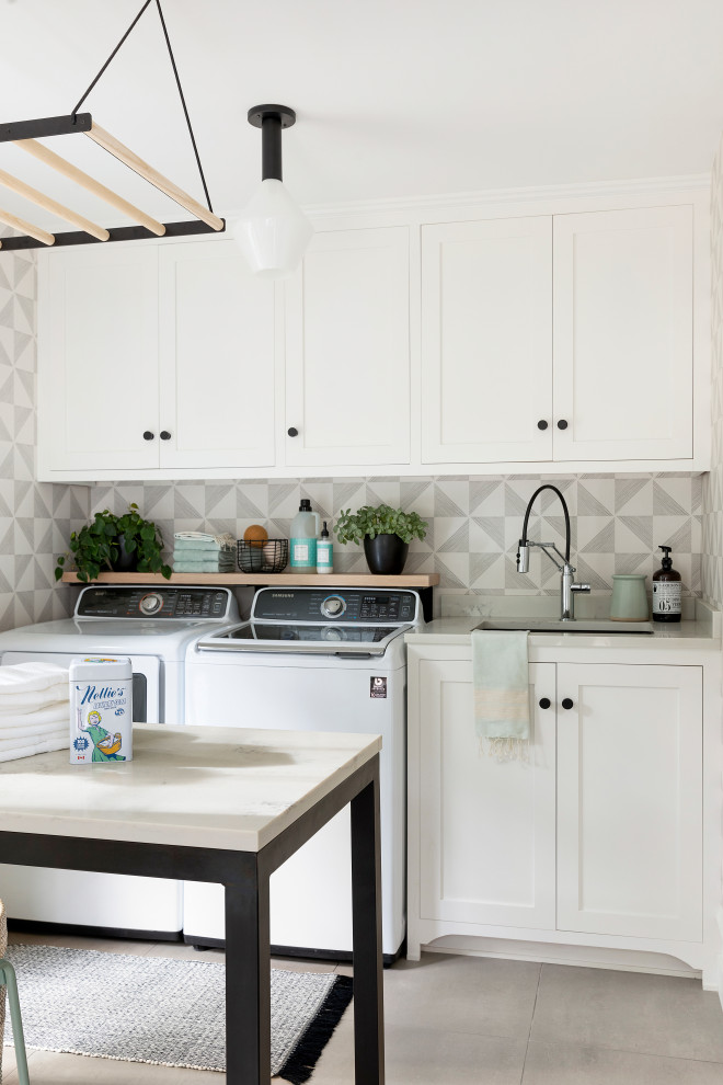 Design ideas for a large classic utility room in Minneapolis with a single-bowl sink, recessed-panel cabinets, white cabinets, engineered stone countertops, porcelain flooring, a side by side washer and dryer, grey floors and white worktops.