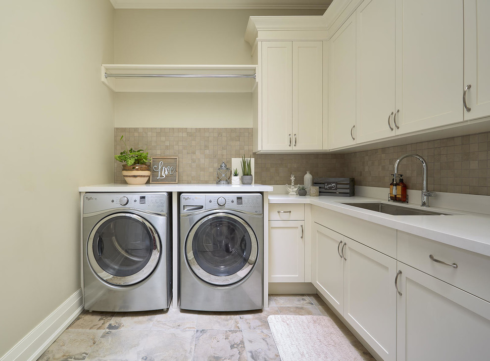 Exempel på en mellanstor klassisk vita l-formad vitt tvättstuga enbart för tvätt, med en undermonterad diskho, skåp i shakerstil, vita skåp, bänkskiva i kvarts, beige väggar, skiffergolv, en tvättmaskin och torktumlare bredvid varandra och flerfärgat golv