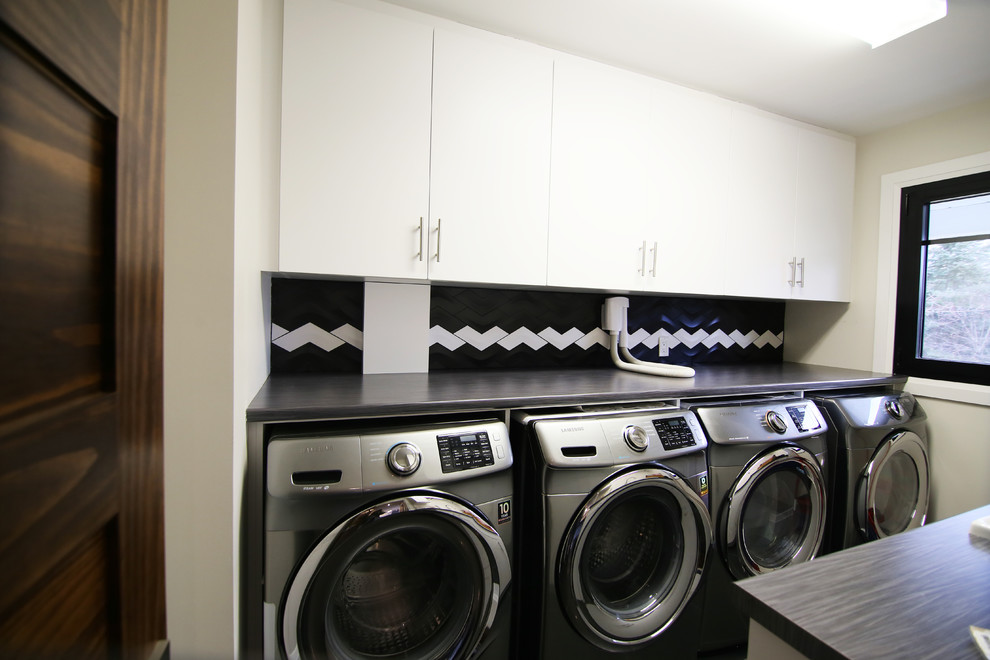 Foto di una sala lavanderia classica di medie dimensioni con lavello da incasso, ante lisce, ante bianche, top in legno, pareti beige, lavatrice e asciugatrice affiancate e top grigio