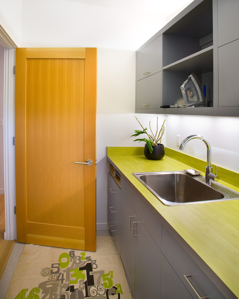 Example of a minimalist laundry room design in San Francisco with green countertops