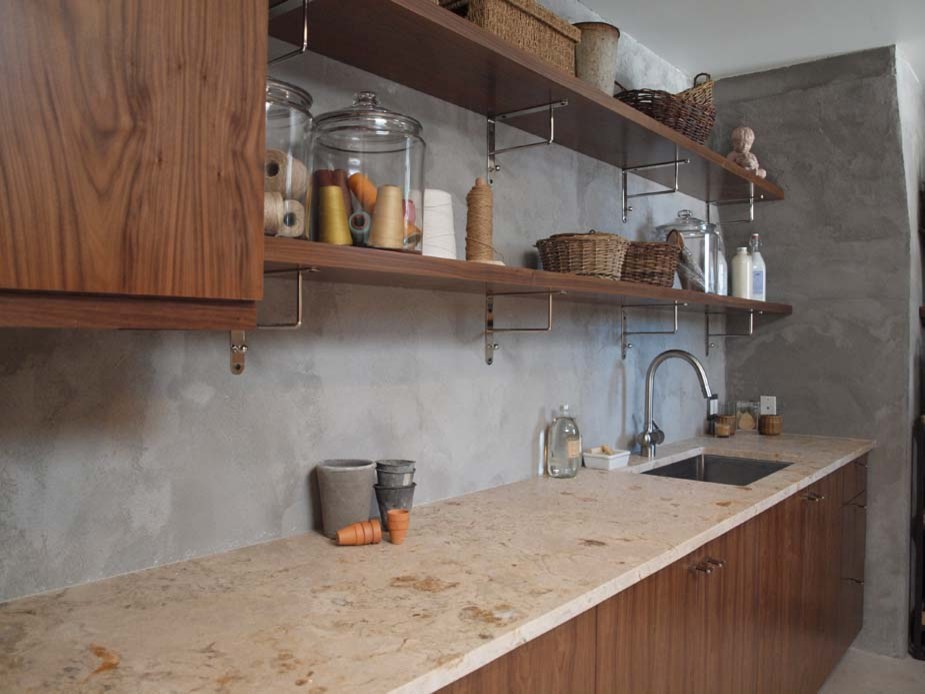 Cette image montre une buanderie linéaire minimaliste en bois brun multi-usage et de taille moyenne avec un évier encastré, un placard à porte plane, un mur gris et un plan de travail en calcaire.