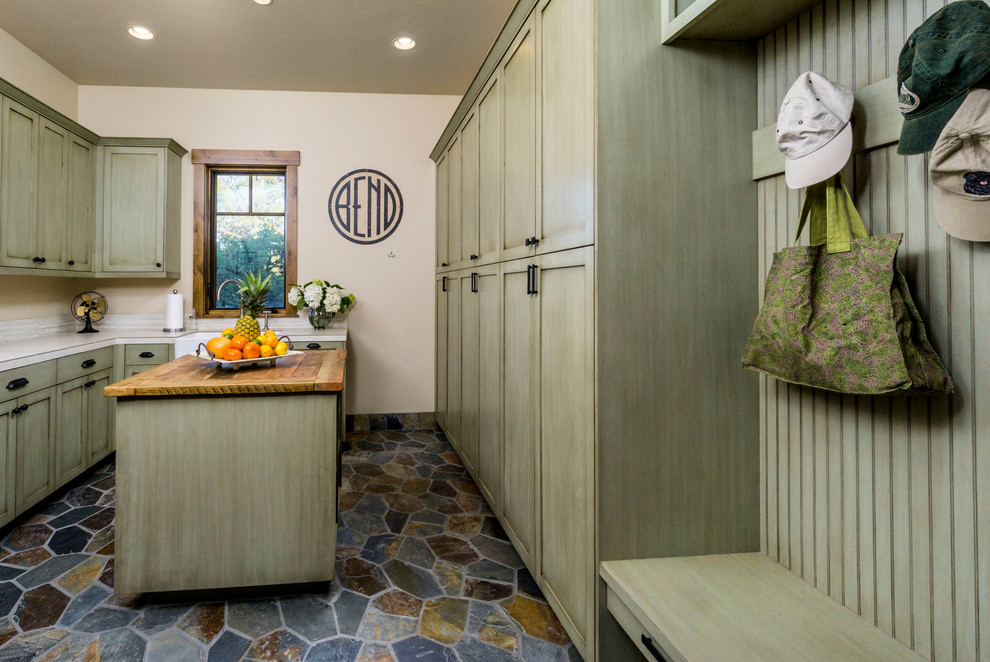 Large farmhouse u-shaped multicolored floor dedicated laundry room photo in Other with a farmhouse sink, shaker cabinets, green cabinets, quartz countertops, beige walls, a side-by-side washer/dryer and beige countertops