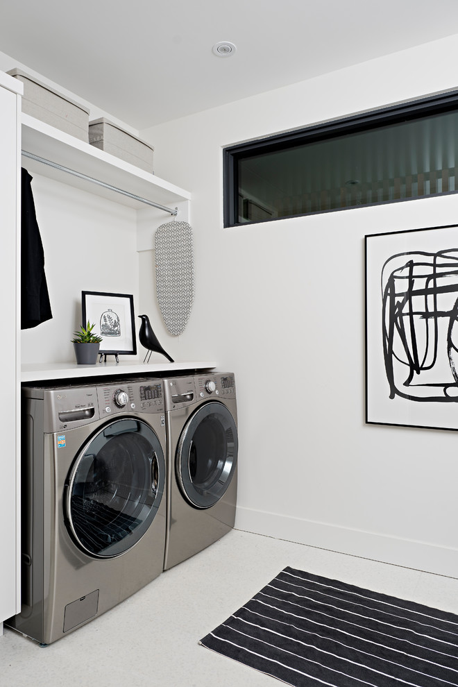 Example of a mid-sized trendy galley porcelain tile and white floor laundry room design in Other with an undermount sink, flat-panel cabinets, quartz countertops, white walls, a side-by-side washer/dryer and white countertops