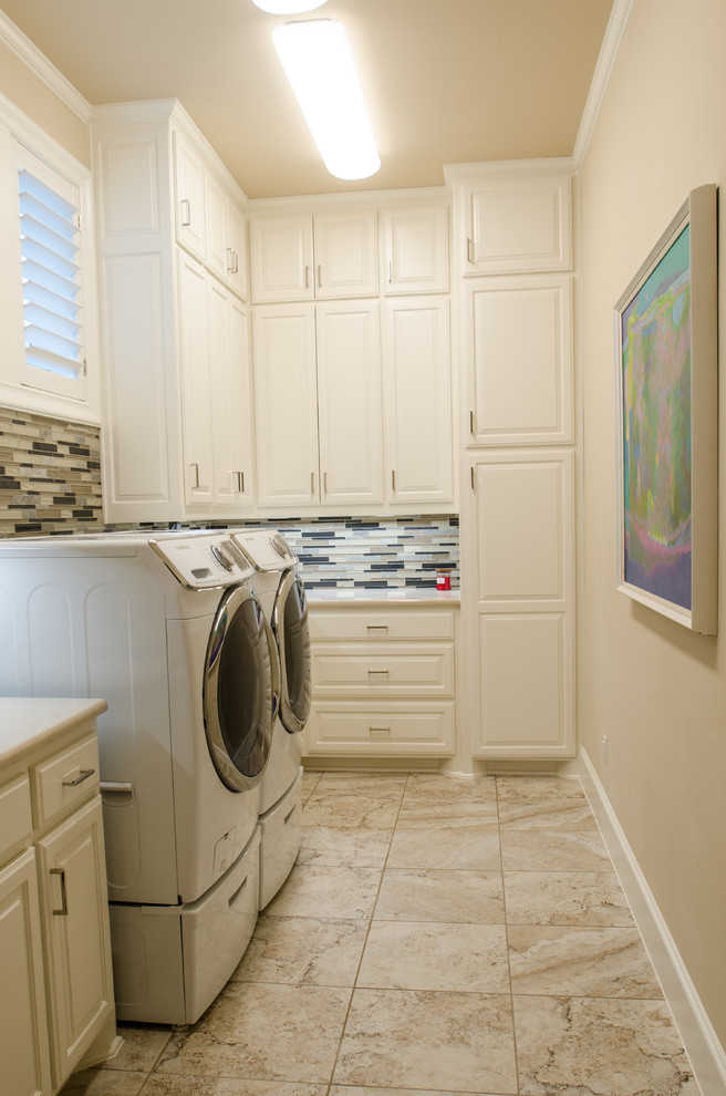 Idéer för att renovera en stor medelhavsstil vita l-formad vitt tvättstuga enbart för tvätt, med luckor med upphöjd panel, vita skåp, bänkskiva i koppar, beige väggar, marmorgolv, en tvättmaskin och torktumlare bredvid varandra, beiget golv och en undermonterad diskho