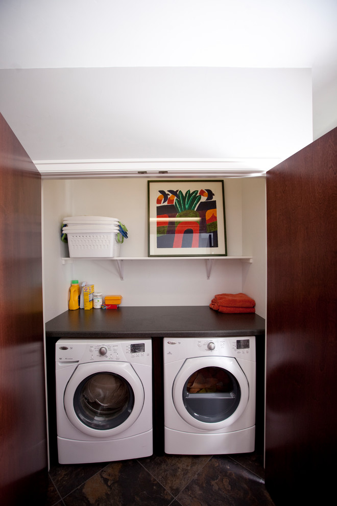 Foto på en linjär liten tvättstuga, med tvättmaskin och torktumlare byggt in i ett skåp