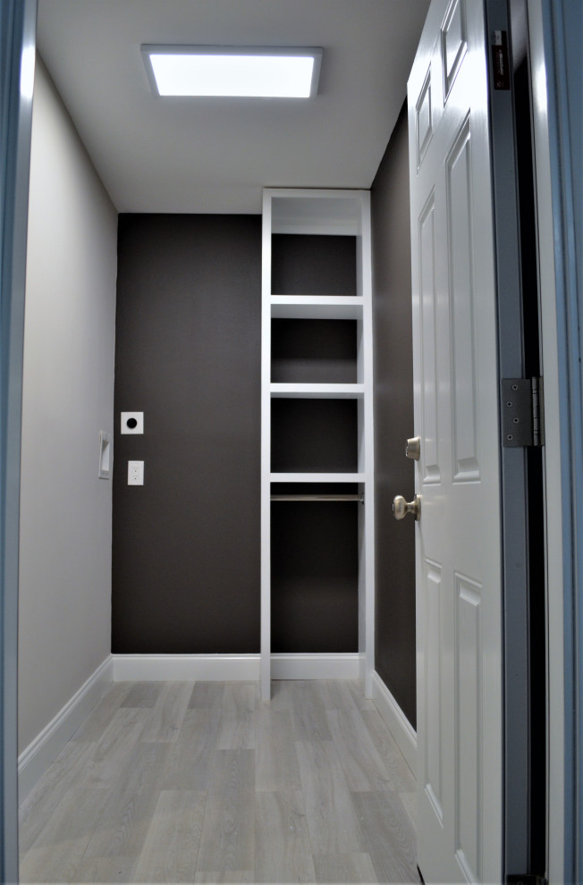 Immagine di una piccola sala lavanderia moderna con pareti nere, pavimento in vinile, lavatrice e asciugatrice a colonna e pavimento grigio