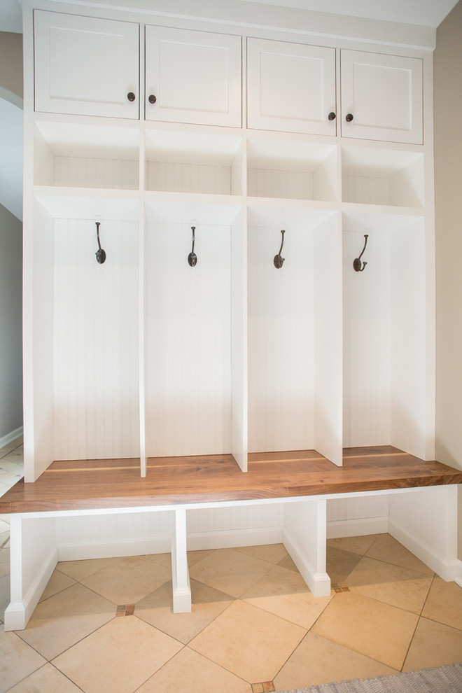 This is an example of a large classic galley utility room in Philadelphia with shaker cabinets, white cabinets, wood worktops, beige walls, ceramic flooring and a side by side washer and dryer.