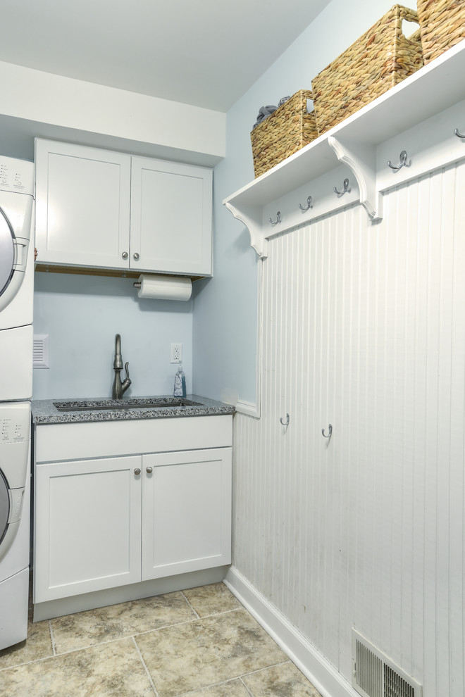 Foto på en mellanstor vintage linjär tvättstuga enbart för tvätt, med en undermonterad diskho, skåp i shakerstil, vita skåp, granitbänkskiva, blå väggar, travertin golv, en tvättpelare och beiget golv