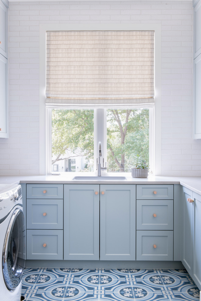 Foto di una sala lavanderia stile marino con lavello a vasca singola, ante in stile shaker, ante blu, pareti bianche, pavimento multicolore e top bianco
