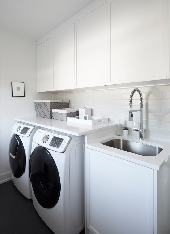 Imagen de lavadero multiusos tradicional renovado con salpicadero blanco, paredes blancas, lavadora y secadora juntas, suelo marrón y encimeras blancas