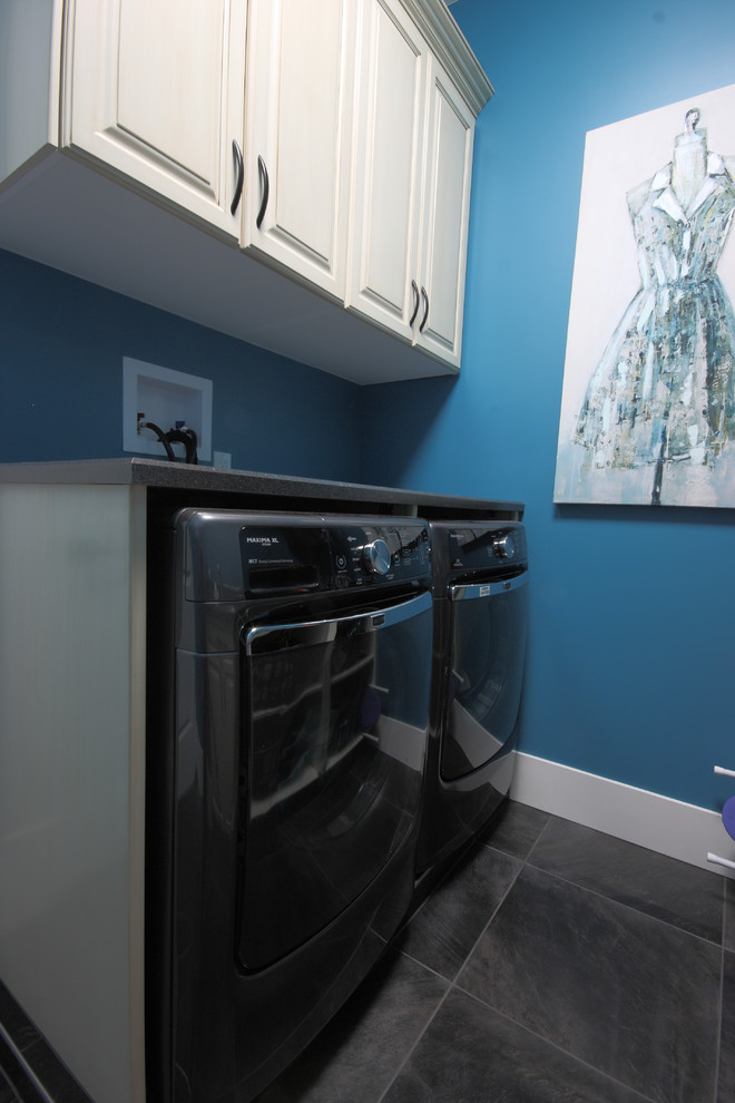 Idee per una piccola sala lavanderia minimal con lavello da incasso, ante con bugna sagomata, ante bianche, top in laminato, pareti blu, lavatrice e asciugatrice affiancate, pavimento in terracotta e pavimento grigio