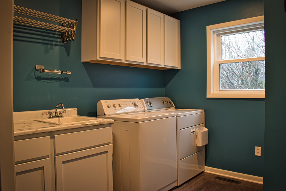 Idee per una sala lavanderia country di medie dimensioni con ante in stile shaker, paraspruzzi blu, paraspruzzi con piastrelle di vetro, pavimento in vinile, pavimento marrone, top multicolore, lavello da incasso, ante bianche, pareti blu e lavatrice e asciugatrice affiancate