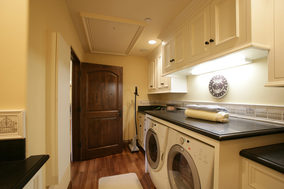 Inspiration for a mediterranean laundry room remodel in San Francisco with white cabinets