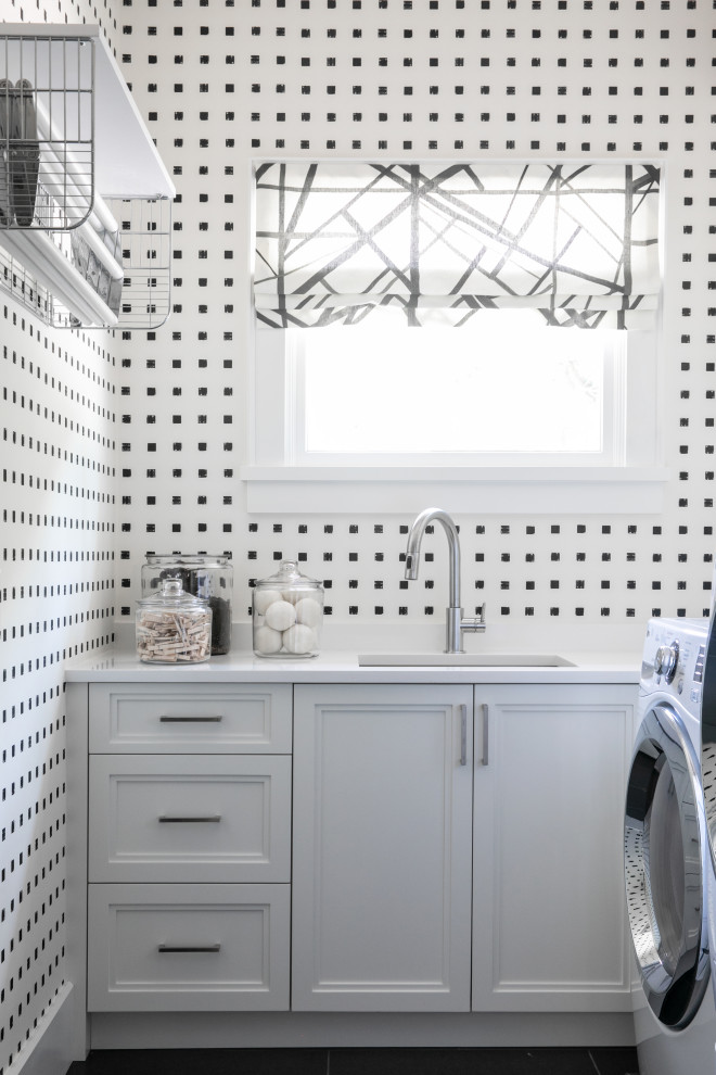 Ispirazione per una sala lavanderia classica con lavello sottopiano, ante con riquadro incassato, ante bianche, pareti multicolore, pavimento nero, top bianco e carta da parati
