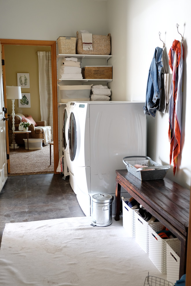 Photo of a small galley utility room in Seattle with grey walls, laminate floors, a side by side washer and dryer and grey floors.