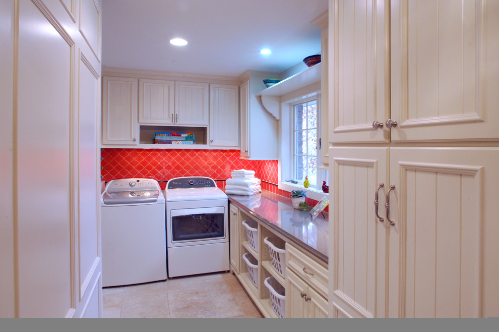 Idéer för eklektiska l-formade tvättstugor enbart för tvätt, med vita skåp, röda väggar, travertin golv, en tvättmaskin och torktumlare bredvid varandra och luckor med infälld panel