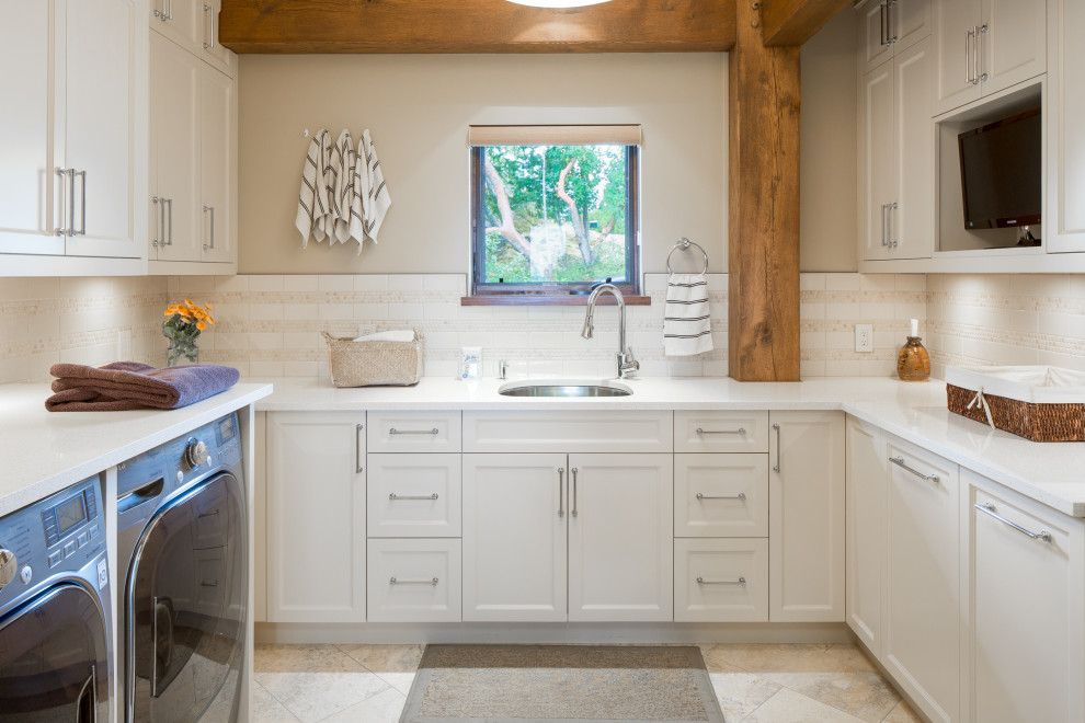 Foto di una lavanderia rustica con lavello sottopiano, ante con riquadro incassato, ante beige, pareti grigie, lavatrice e asciugatrice affiancate, pavimento beige e top bianco