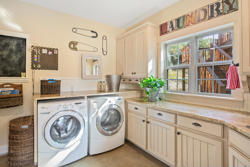 オースティンにあるラスティックスタイルのおしゃれな洗濯室 (ベージュのキャビネット、ベージュの壁、左右配置の洗濯機・乾燥機、ベージュの床、ベージュのキッチンカウンター) の写真