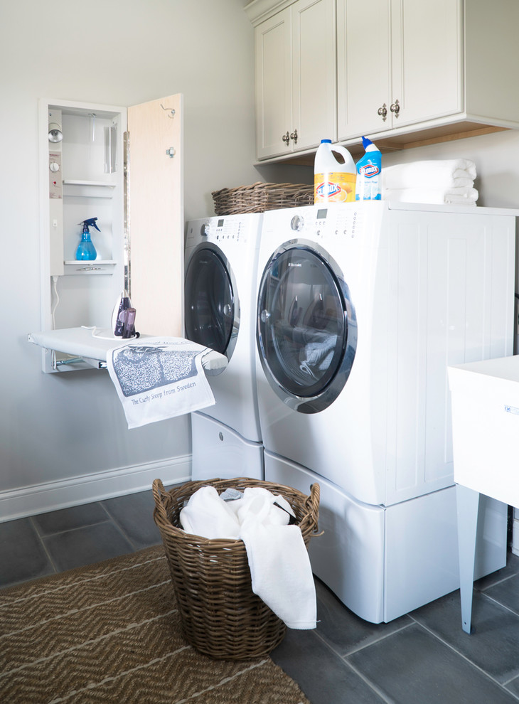 Mid-sized farmhouse porcelain tile and gray floor laundry room photo in St Louis with white cabinets, quartz countertops, beige walls, a side-by-side washer/dryer, recessed-panel cabinets and an utility sink