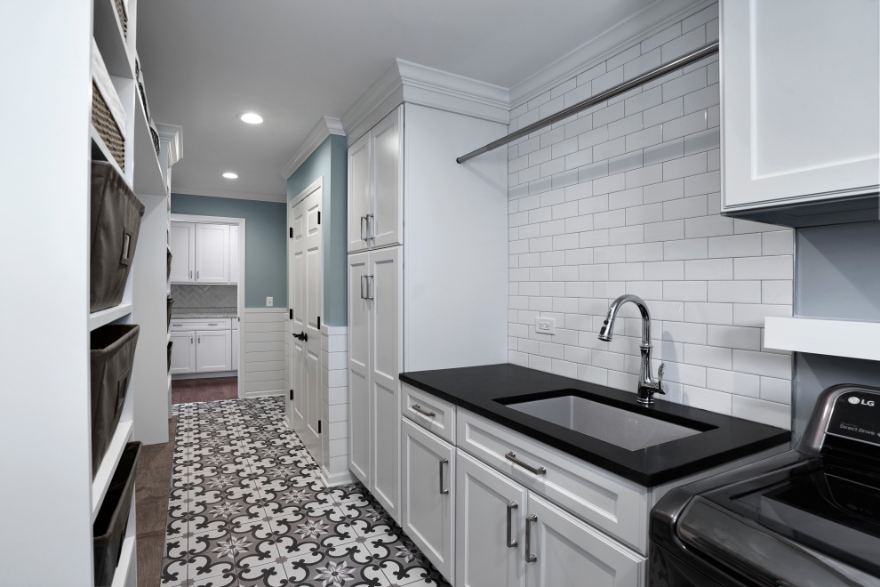 This is an example of a medium sized traditional galley separated utility room in Chicago with a submerged sink, recessed-panel cabinets, white cabinets, granite worktops, blue walls, ceramic flooring, a side by side washer and dryer, multi-coloured floors and black worktops.