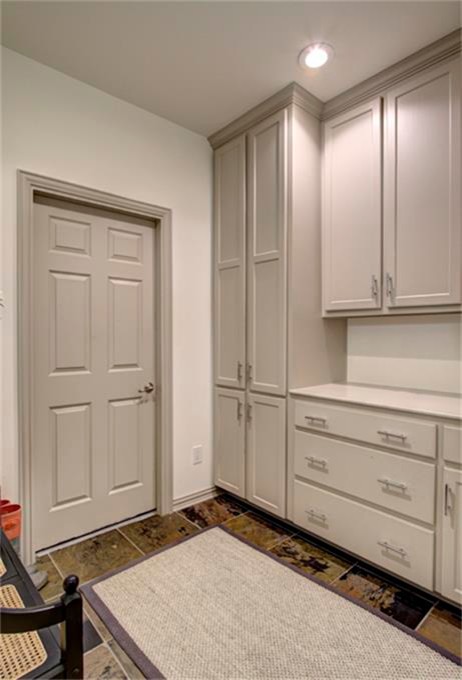 Cette image montre une petite buanderie linéaire traditionnelle dédiée avec un placard à porte plane, des portes de placard grises, un plan de travail en bois, un mur blanc et un sol en ardoise.