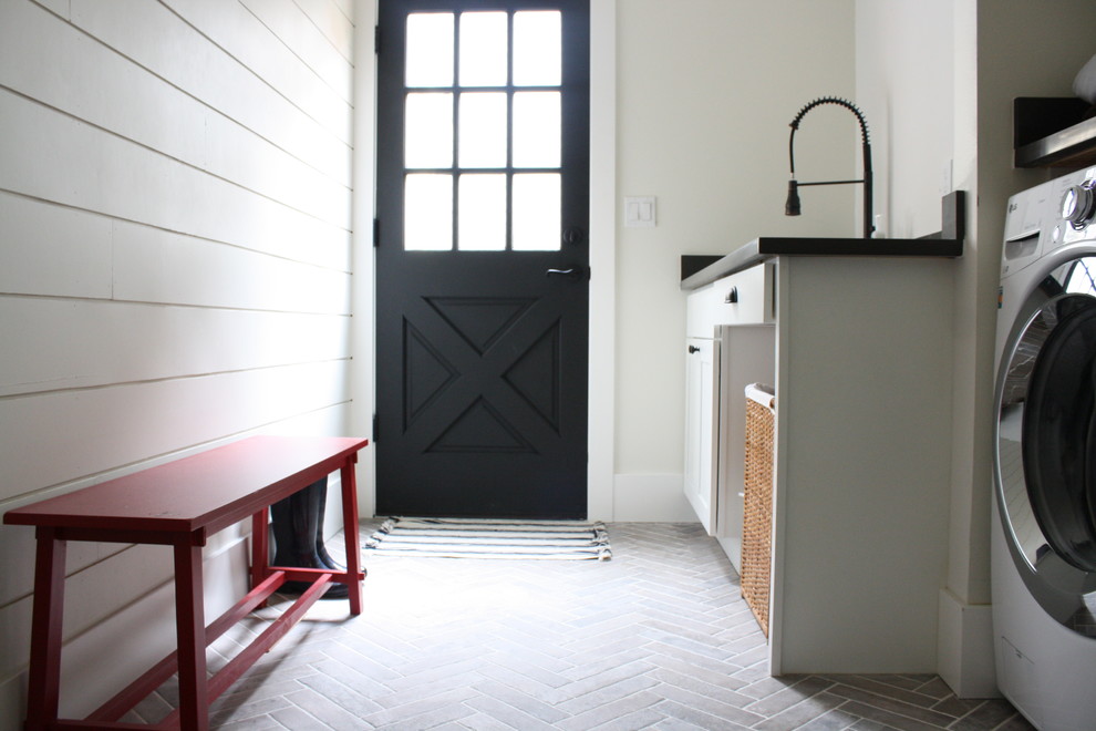 Inspiration for a farmhouse galley ceramic tile dedicated laundry room remodel in Seattle with an undermount sink, shaker cabinets, white cabinets, quartz countertops, white walls and a side-by-side washer/dryer