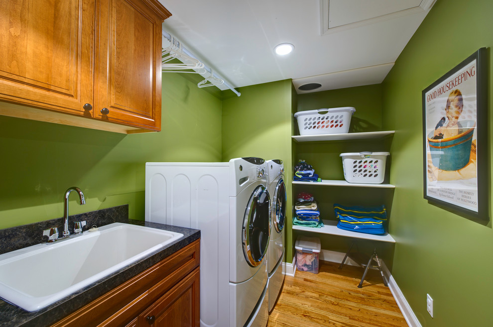 Imagen de lavadero tradicional con fregadero encastrado, paredes verdes y lavadora y secadora juntas