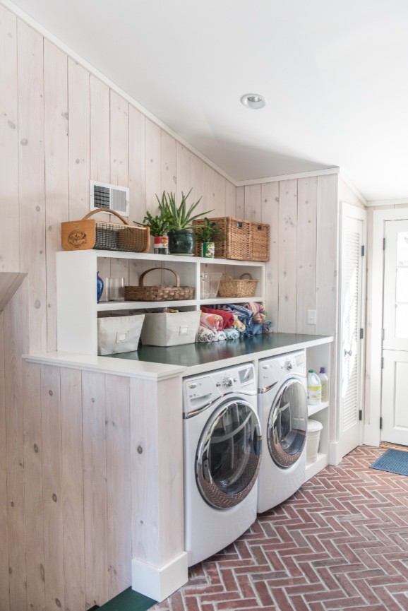 ボストンにある低価格の小さなトラディショナルスタイルのおしゃれな家事室 (ll型、オープンシェルフ、白いキャビネット、木材カウンター、白い壁、レンガの床、左右配置の洗濯機・乾燥機) の写真