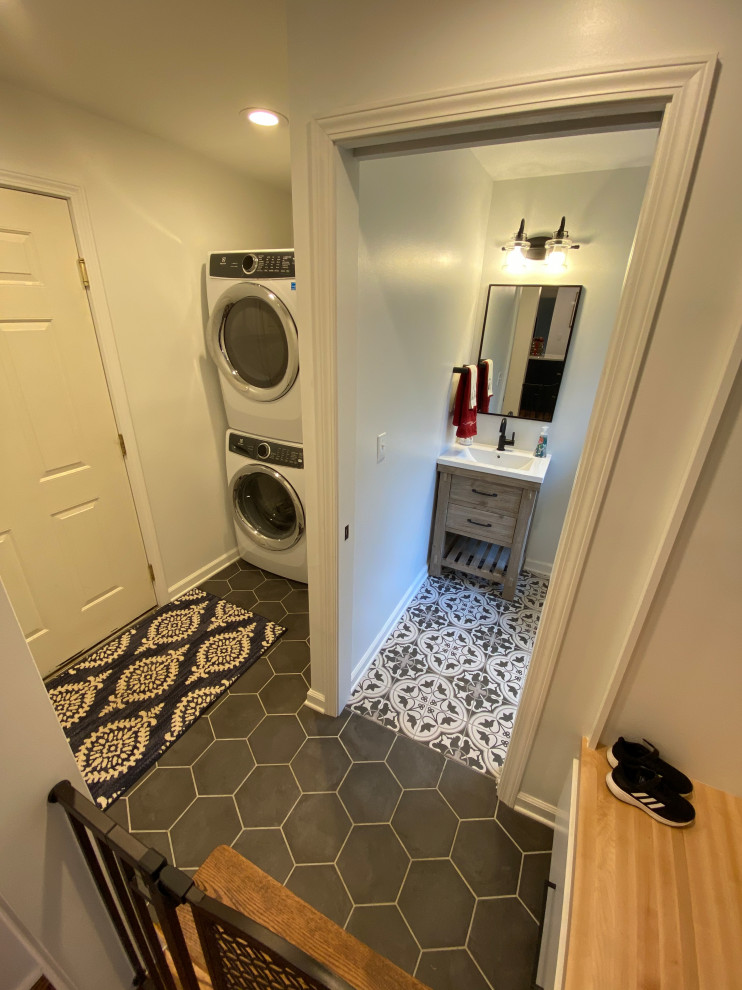 Exempel på en liten lantlig bruna linjär brunt tvättstuga enbart för tvätt, med skåp i shakerstil, vita skåp, träbänkskiva, vita väggar, klinkergolv i porslin, en tvättpelare och grått golv