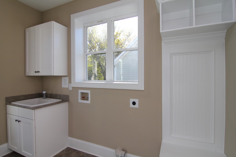 Small arts and crafts galley ceramic tile utility room photo in Raleigh with a drop-in sink, recessed-panel cabinets, white cabinets, solid surface countertops, beige walls and a side-by-side washer/dryer