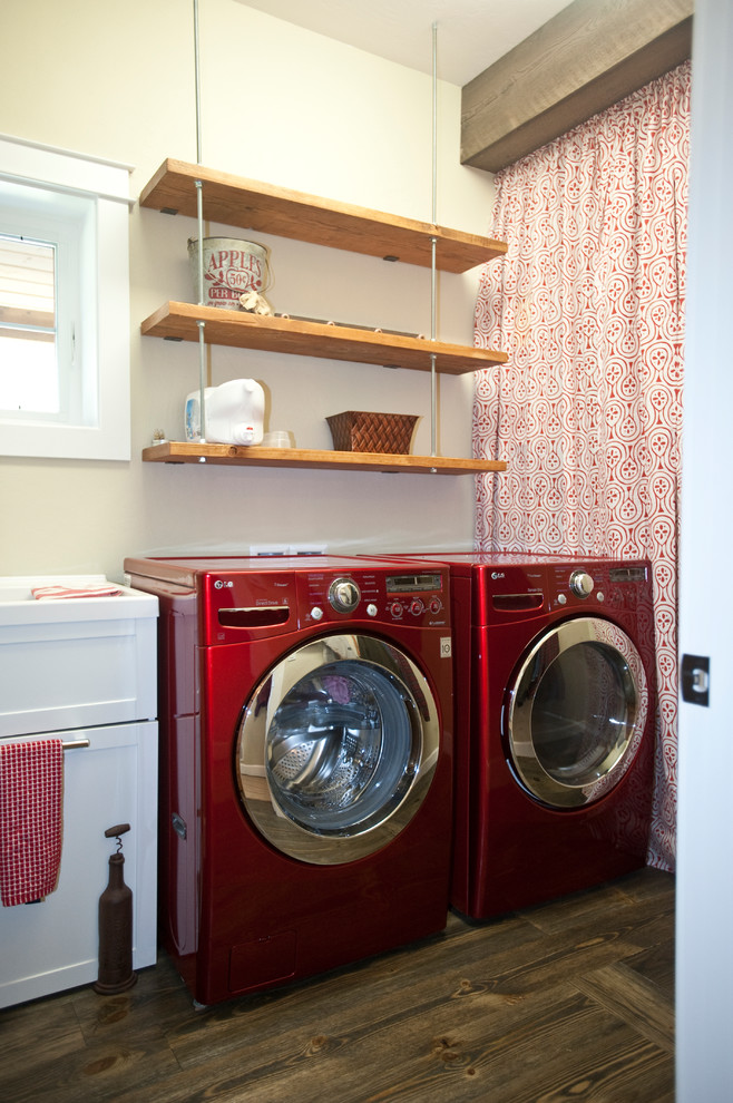 Immagine di una lavanderia multiuso stile rurale di medie dimensioni con pareti grigie, parquet scuro e lavatrice e asciugatrice affiancate