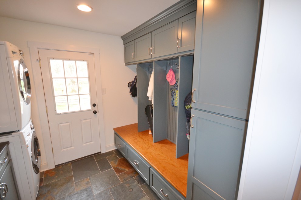 Medium sized traditional single-wall utility room in Philadelphia with flat-panel cabinets, wood worktops, white walls, ceramic flooring, a stacked washer and dryer and a belfast sink.