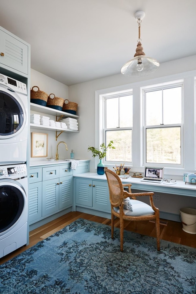 Foto de lavadero en L marinero con armarios con puertas mallorquinas, puertas de armario azules, suelo de madera en tonos medios y suelo marrón