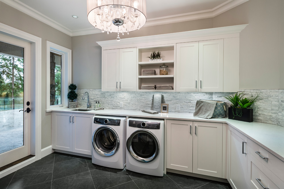 Large transitional l-shaped porcelain tile and black floor dedicated laundry room photo in Vancouver with an undermount sink, recessed-panel cabinets, white cabinets, quartz countertops, gray walls and a side-by-side washer/dryer