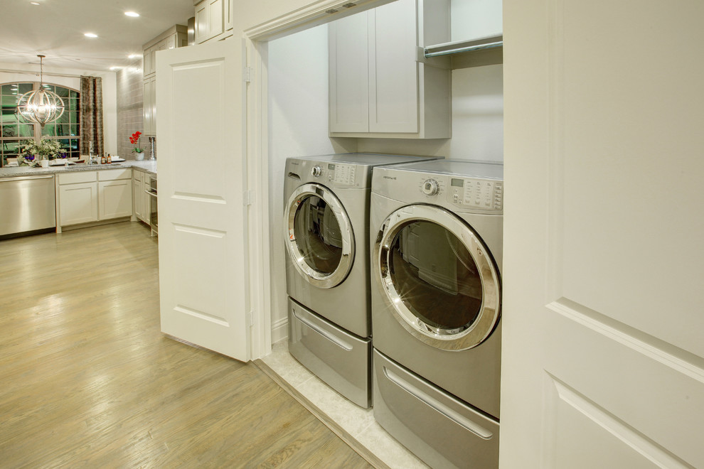 Immagine di una piccola lavanderia chic con ante beige, pareti beige, pavimento con piastrelle in ceramica e lavatrice e asciugatrice affiancate