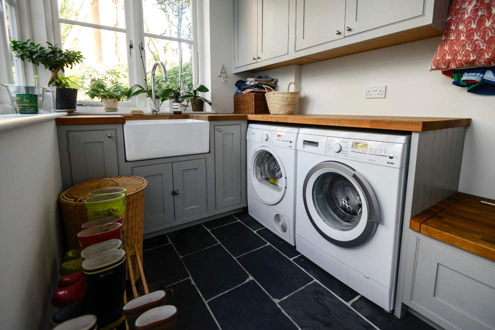Inspiration for a traditional utility room in London with black floors.