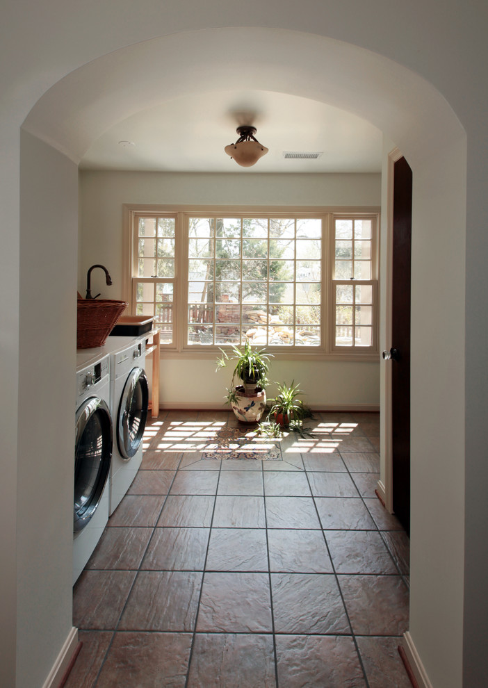 Inspiration for a timeless single-wall porcelain tile dedicated laundry room remodel in DC Metro with a farmhouse sink, white walls and a side-by-side washer/dryer