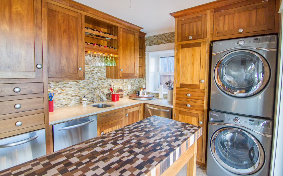 Photo of a beach style utility room in Charleston with a submerged sink, shaker cabinets, medium wood cabinets, a stacked washer and dryer and multicoloured worktops.