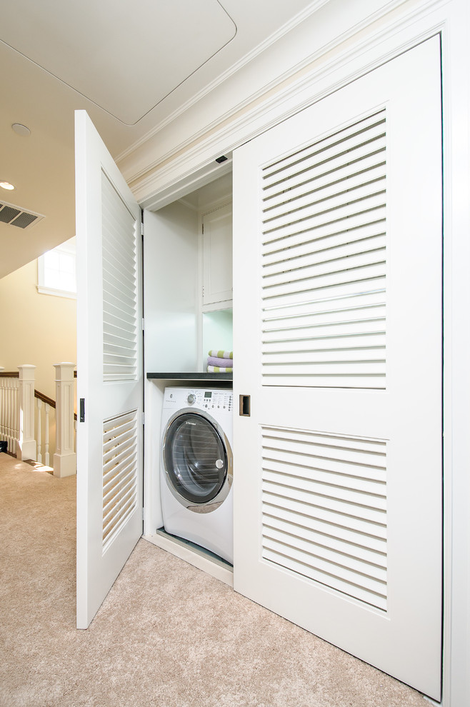 Ejemplo de armario lavadero lineal tradicional renovado con armarios con paneles lisos, puertas de armario blancas, encimera de mármol, lavadora y secadora juntas y paredes beige